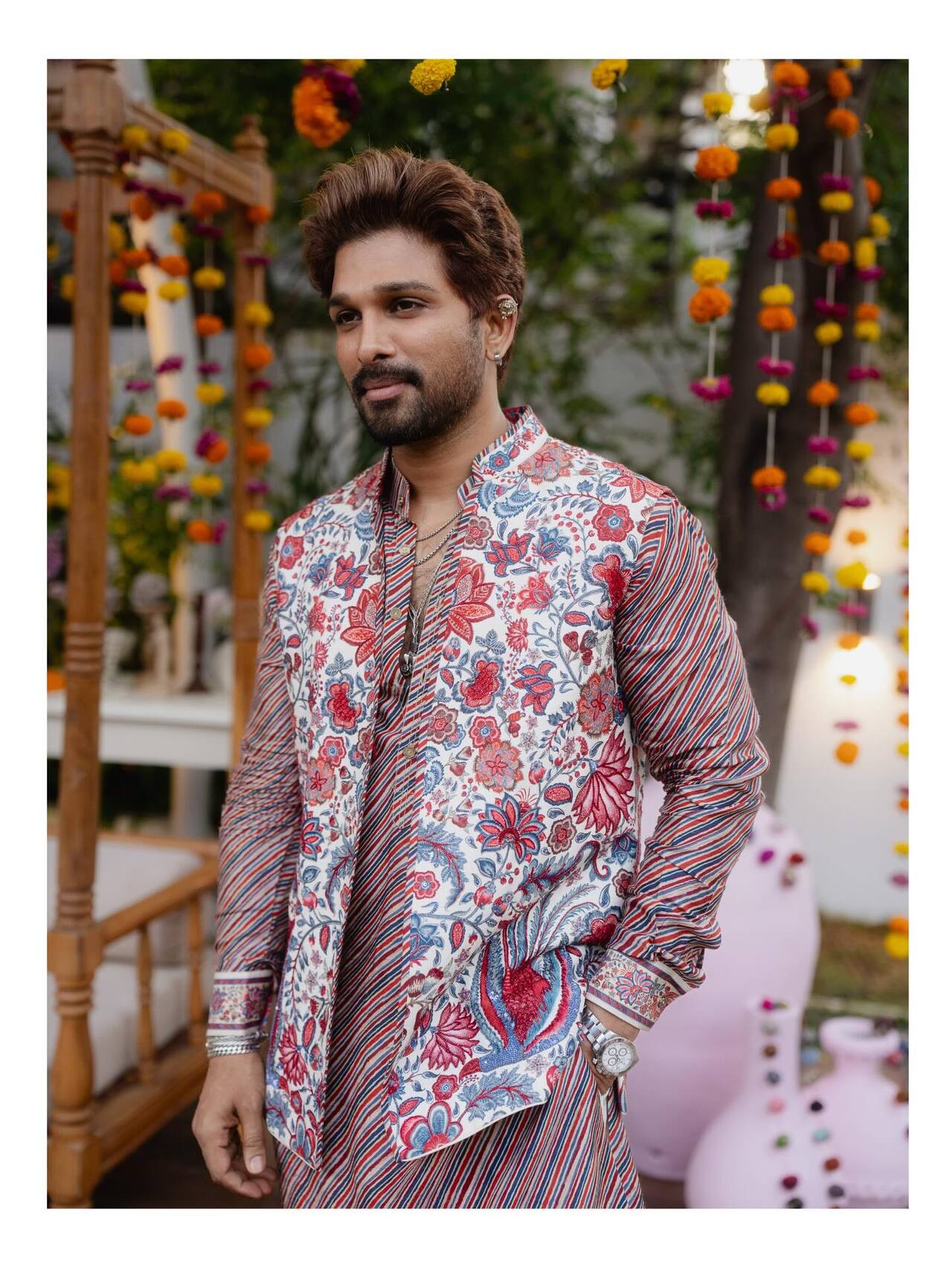Allu Arjun dazzled in festive style in a statement Torani&nbsp;kurta set featuring bold floral prints in shades of red and blue. The outfit layered a patterned Nehru jacket with a contrasting striped long kurta, adding depth and a contemporary twist to traditional menswear.